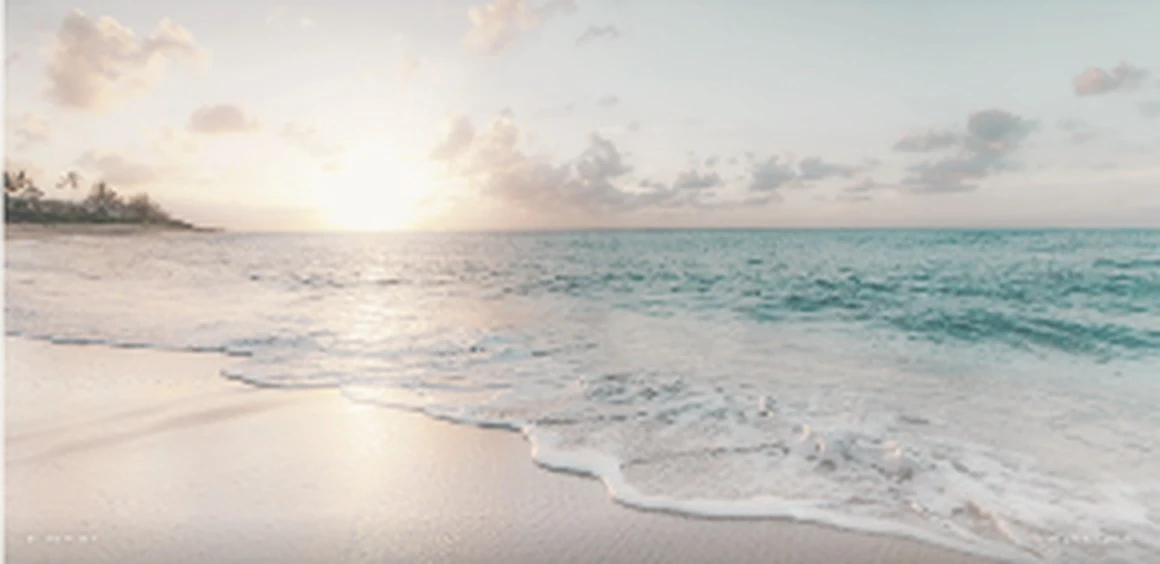 Softly lit waves meeting a peaceful sandy shoreline